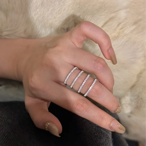 Detailed view of four stacked 925 silver rings with pavé set zircon stones on finger
