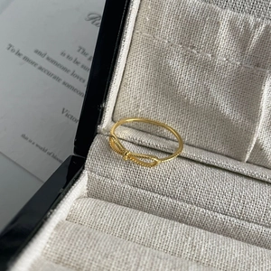 Detailed view of S925 silver bow ring with gold plating and beaded edge texture