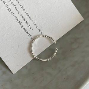 Detailed view of silver S925 bamboo joint ring on artistic paper background