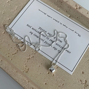 Détail du collier coeur en argent 925 avec chaîne à boules sur plateau en pierre