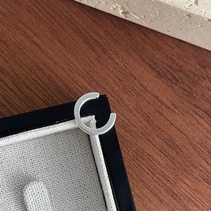 Close-up of minimalist S925 sterling silver ear cuff with a polished metallic finish