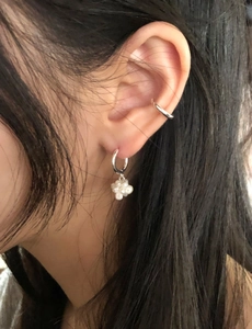 Macro detail of S925 sterling silver ear cuffs with small white pearl flower clusters