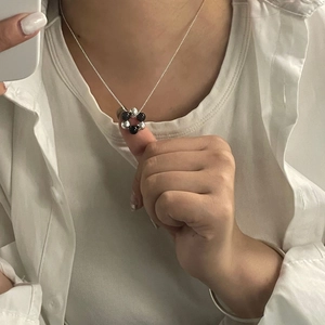 Close-up of minimalist S925 silver necklace with black and silver beads on a model