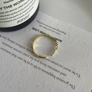Macro view of a gold-plated bamboo joint open ring on an aesthetic paper background