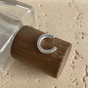 Close-up of polished silver S925 sterling silver ear cuff with minimalist C-shape design