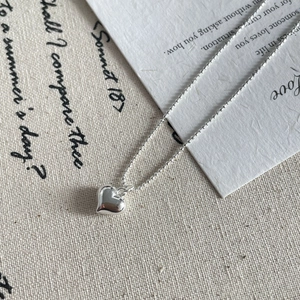Détail du collier coeur en argent S925 sur chaîne à billes avec fond poétique élégant