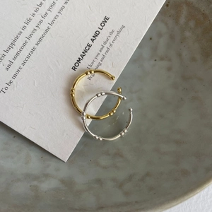 Macro detail of gold and silver bamboo-joint rings on textured display cards