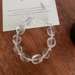 Détail du bracelet en perles de cristal ovales transparentes avec fermoir mousqueton argenté et chaîne