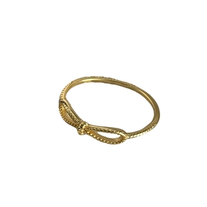 Minimalist S925 sterling silver bow ring with golden beaded texture on white background