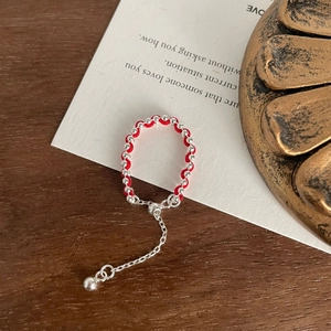 Macro detail of handmade red woven string bracelet with silver beads and adjustable chain