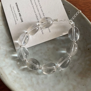 Gros plan du bracelet en cristal blanc ovale avec billes argentées et fermoir ajustable