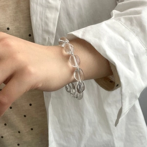 Détail d'un bracelet en argent S925 avec perles de cristal blanc ovales porté au poignet