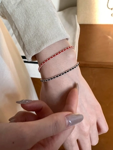 Close-up of minimalist S925 sterling silver beads woven with red and black cord bracelets