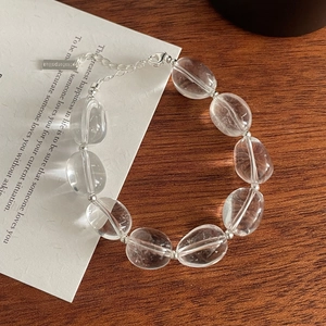 Vue détaillée du bracelet en argent avec perles de cristal ovales sur une table en bois