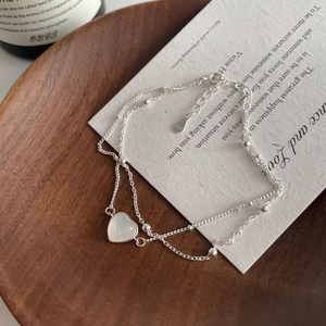 Gros plan du poinçon S925 sur un bracelet double chaîne avec pendentif en cœur