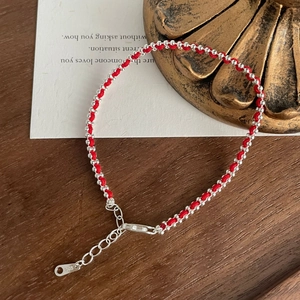 Close-up of S925 sterling silver lobster clasp and hallmark on red woven bracelet
