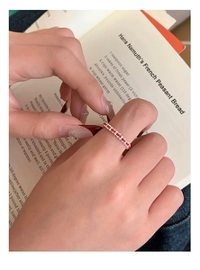 Detailed close-up of handmade red rope woven ring with delicate white pearls