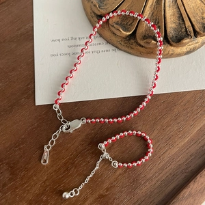 Detail of red braided string bracelet and ring set with S925 sterling silver beads