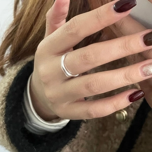 Gros plan d'une bague vague en argent sterling S925 avec finition polie sur la main