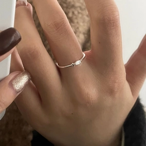 Close-up of minimalist S925 sterling silver ring with small fish design on a model