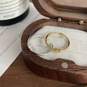 Detailed top view of minimalist gold and silver rings in a luxury wooden jewelry box