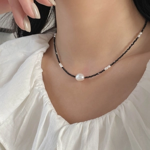 Détail d'un collier en perles facettées noires avec une perle d'eau douce sur un mannequin