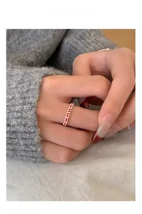 Close-up of handmade S925 sterling silver ring with woven red thread design on finger