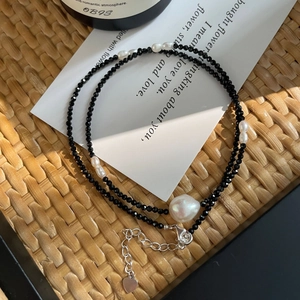 Collier en argent S925 avec perles noires et perles de culture sur un tapis tissé