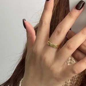 Detail of minimalist 925 sterling silver gold ring featuring textured lava surface on finger
