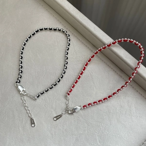 Vue macro détaillée de perles en argent sterling S925 et bracelets tissés en rouge et noir