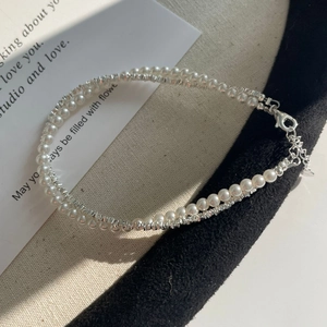 Detail of S925 silver beaded bracelet featuring white pearls and metallic silver beads