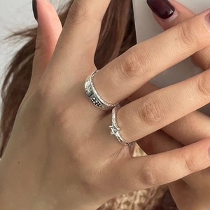 Detail of 925 silver rings set with star embossed wide band and twisted star ring