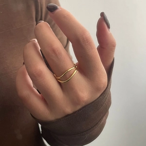 Minimalist double layer wavy golden ring for women shown on index finger in elegant style
