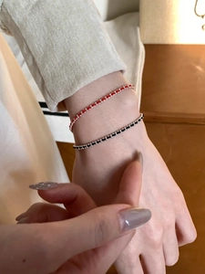 Gros plan de bracelets faits main en perles d'argent 925 et fil de soie rouge et noir