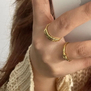 Macro detail of gold-plated 925 silver rings with hammered texture and twisted design