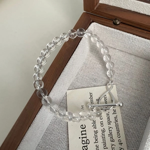 Detail shot of a crystal bead bracelet with a silver toggle clasp in a wooden box