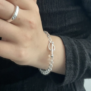 Detailed view of silver infinity OT clasp on a transparent beaded crystal bracelet