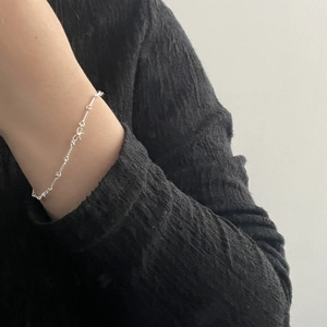 Bracelet minimaliste en argent sterling S925 avec nœud torsadé au poignet d'une femme