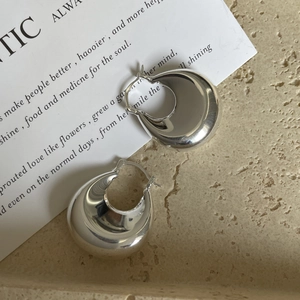 Créoles en U bombées en argent sterling S925 poli sur une surface en pierre minimale