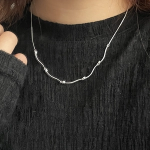 Elegant S925 sterling silver wavy necklace with zircons worn on a black sweater