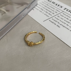 Macro detail of gold star ring with unique rock texture on a minimal grey surface