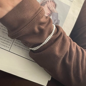 Elegant double-layer S925 silver beaded bracelet with white pearls on a knit sleeve background