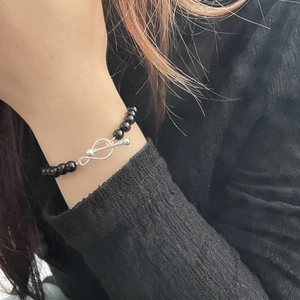 Detail of silver OT toggle clasp and black onyx bead bracelet on a female wrist