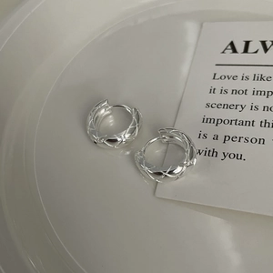 Macro shot of silver S925 sterling silver hoop earrings with a rhombic pattern design