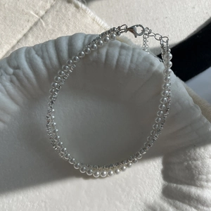 Detail view of double-layer S925 silver bracelet with pearls and lobster clasp on tray