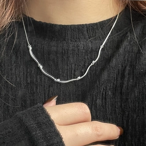 Close-up of S925 sterling silver wavy chain necklace with shimmering zircon details