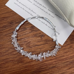 Elegant 925 sterling silver wave bracelet with clear crystal quartz on a wooden background