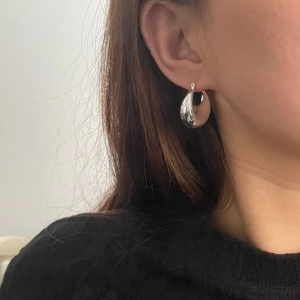 Boucles d'oreilles créoles S925 en argent poli effet miroir portées par un mannequin
