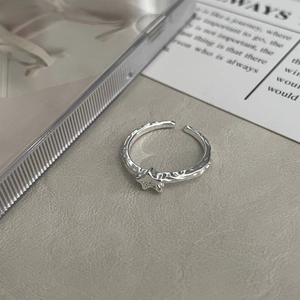 Detail of 925 sterling silver star ring with textured hammer finish on a minimalist band