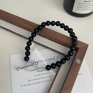 Detail of black agate beads bracelet featuring a silver S925 infinity toggle clasp